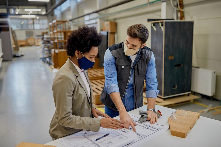 african-american-businesswoman-carpenter-wearing-face-masks-while-analyzing-design-plans-production-facility_637285-11919